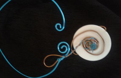 collier en fils alu turquoise et marron avec grosse perle plate blanche et perle shamballa turquoise.
