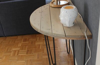 Une console demi-lune avec un touret en bois et des pieds en métal