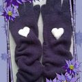Petits coeurs de neige posés sur des gants violets