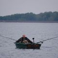 Un pêcheur était assis au bord de la mer, au