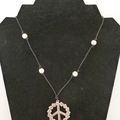 Léger, mais présent avec son gros médaillon peace and love à fleurs, ce collier en coton ciré, et perles blanches en howlite !