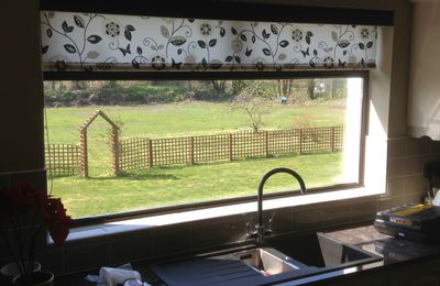 A roller blind with a black pelmet, on a sunny