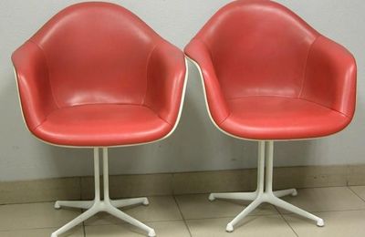 Suite de quatre fauteuils coque en fibre de verre blanche moulée et gainée de skaï orange. Création Charles et Ray EAMES. 