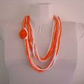 collier écharpe en chaînettes blanches et orange avec fleur crochetée.