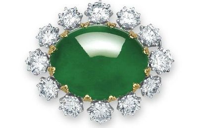 A magnificent oval jadeite cabochon and diamond pendant-brooch, mounted by Carvin French