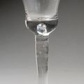 Verre en verre soufflé à jambe pleine, large pied rond légèrement cloche. XVIIIe siècle