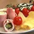 Rouleaux de jambon au fromage fondu et concombre, chips chaudes et tomates cerises