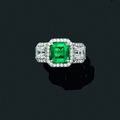 Très belle bague en or gris ornée d'une émeraude carrée épaulée de deux diamants carrés