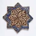A Kashan lustre painted star-shaped tile with a rosace, early 14th century 