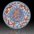 A magnificent, fine and rare iron-red and underglaze-blue ‘nine dragon’ charger, Qianlong seal mark and period