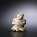 A rare pale brown jade seated male figure, Eastern Han Dynasty (25-220)