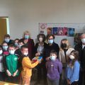 les enfants remettent la boite du Goûter à Pharmacie Humanitaire Internationale 