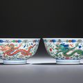 A fine and rare pair of wucai 'Dragon and Phoenix' bowls, Kangxi six-character marks within double circles and of the period 